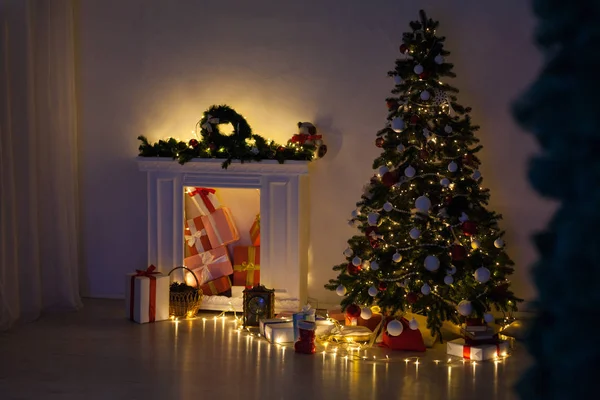 Рождественская елка со светящимися гирляндами и подарки на Новый год — стоковое фото