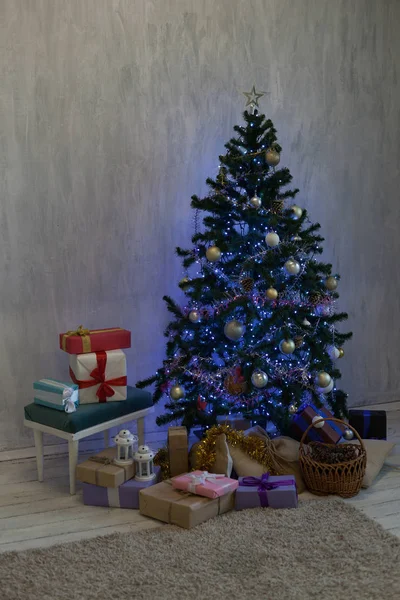 Рождественская елка со светящимися гирляндами и подарки на Новый год — стоковое фото
