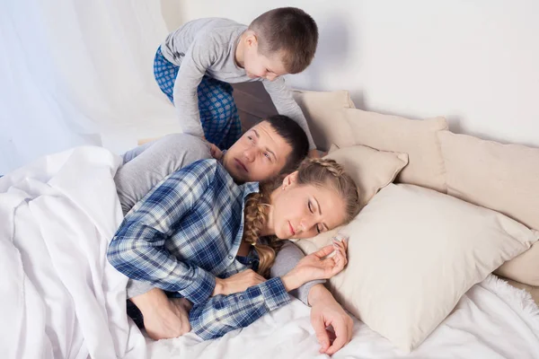 Mama Papa und Sohn am Morgen zu Hause auf dem Bett liegend — Stockfoto