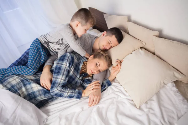 Мама тато і син вранці лежать на ліжку вдома — стокове фото