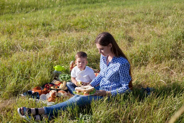 Ritratto di una madre con un figlio piccolo mangiare ad un picnic nella foresta — Foto Stock