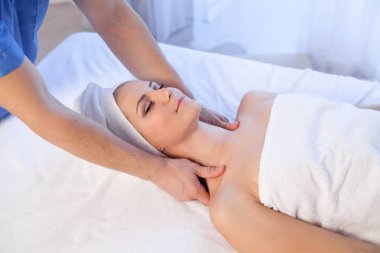 bir masaj terapisti bir kadın tedavi yüz ve vücut bakımları masaj yapıyor