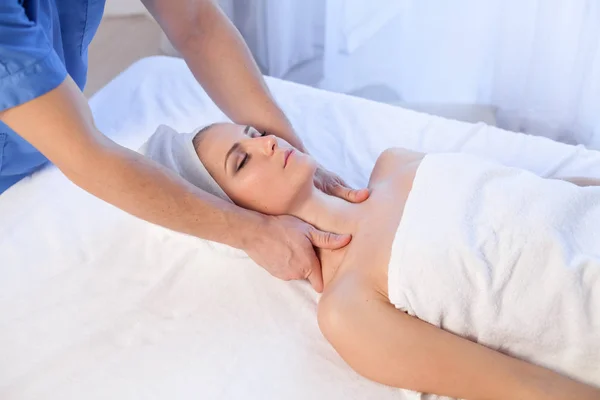 A massage therapist makes a woman face and neck massage in the Spa — Stock Photo, Image