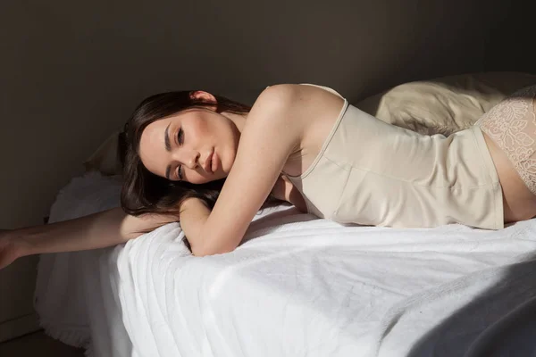 Portret pięknej kobiety w bieliźnie na łóżku muzyki — Zdjęcie stockowe