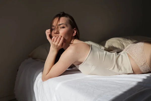Portret van mooie vrouw in lingerie op bed muziek — Stockfoto