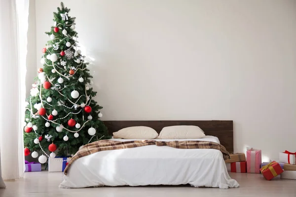 Slaapkamer decor Kerst nieuwjaar boom bed presenteert de achtergrond van het interieur — Stockfoto