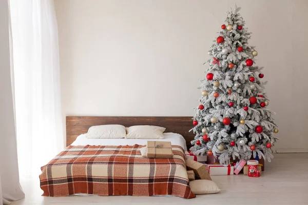 Kerstboom in de slaapkamer met bed en giften van de vakantie winter briefkaart voor Nieuwjaar — Stockfoto