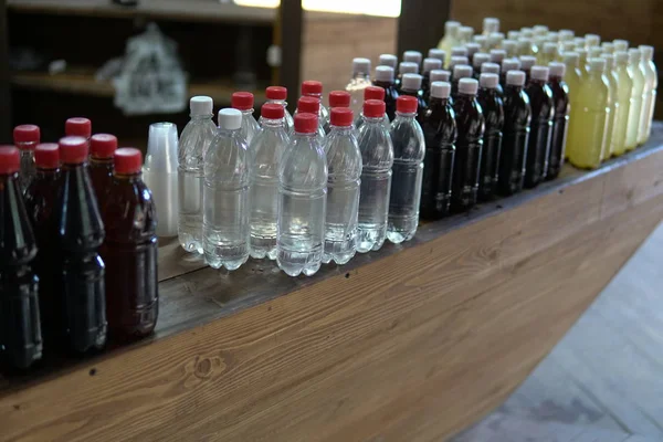 Muchas botellas de plástico con un líquido de un color diferente — Foto de Stock