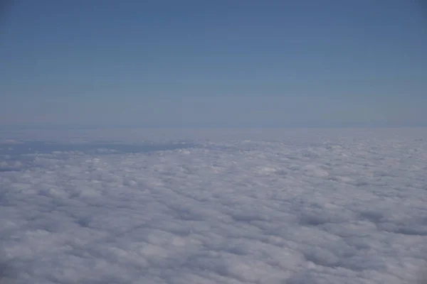 Cielo azul sobre nubes blancas desde el interior del avión — Foto de Stock