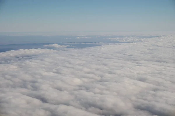 Blauer Himmel über weißen Wolken aus dem Flugzeug — Stockfoto
