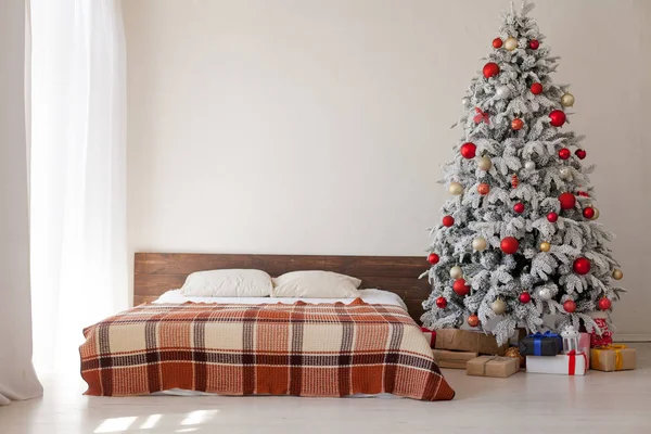 Weihnachtsbaum in einem weißen Schlafzimmer mit Bett Interieur von Neujahrsgeschenken — Stockfoto