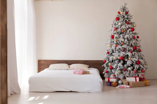 Árbol de Navidad en un dormitorio blanco con cama interior de regalos de año nuevo —  Fotos de Stock