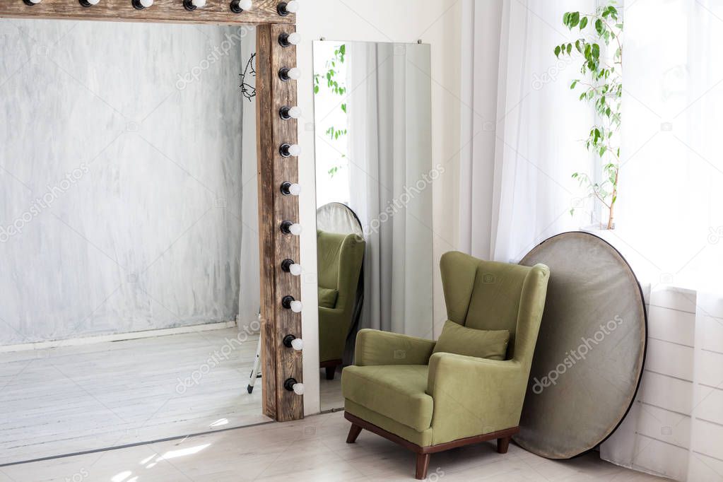 Green armchair in white PhotoStudio mirror lamps