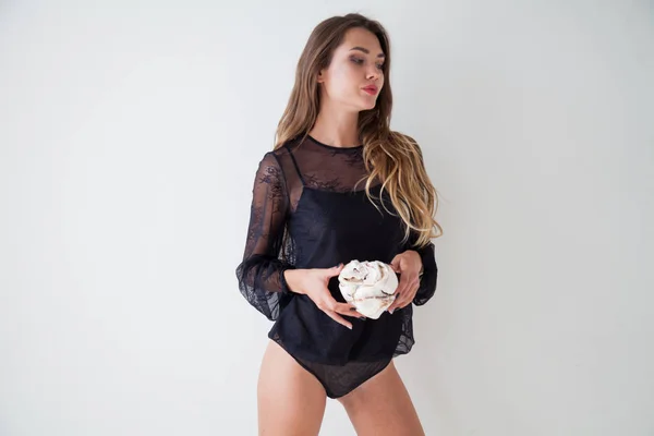 Bela mulher em lingerie come um bolo doce — Fotografia de Stock