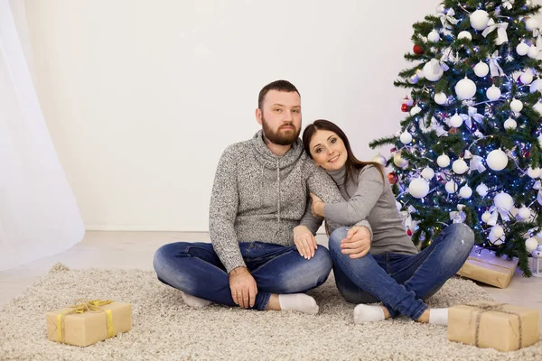En man och en kvinna sitta på julgran nyår gåvor semester vinter — Stockfoto