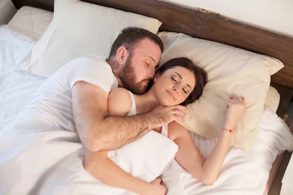 Муж и жена просыпаются утром в спальне любви выходных — стоковое фото