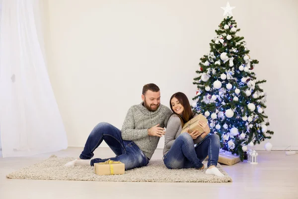 Man and woman open Christmas presents Christmas tree with Garland new year — Stock Photo, Image