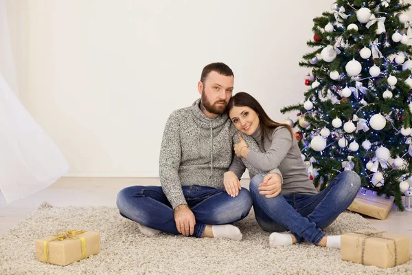 Man and woman open Christmas presents Christmas tree with Garland new year — Stock Photo, Image