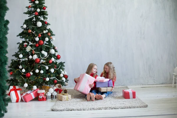 Duas meninas pequenas loira em vestido vermelho em presentes de Natal feriado do ano novo — Fotografia de Stock