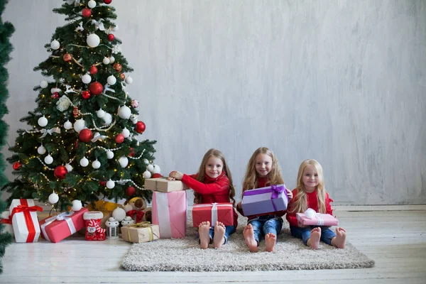 Три маленькие девочки блондинка в красном платье на рождественские подарки Новый год праздник — стоковое фото