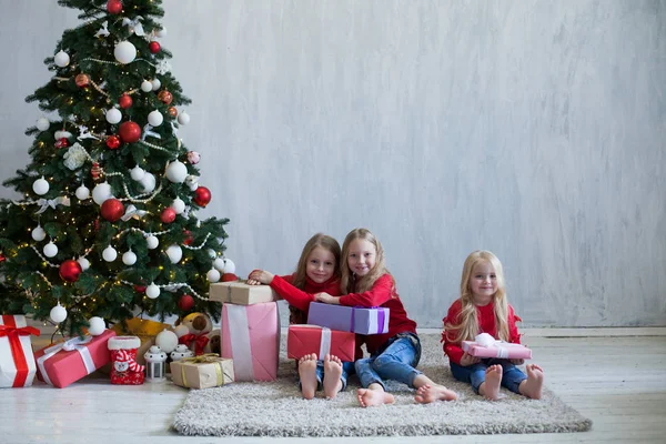 Três meninas pequenas loira em vestido vermelho em presentes de Natal feriado do ano novo — Fotografia de Stock