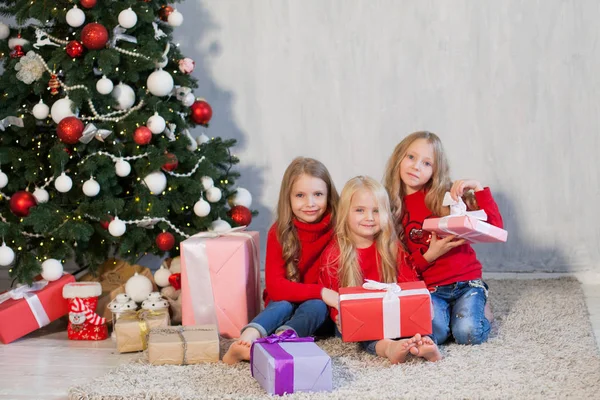 Tres niñas pequeñas rubia en vestido rojo en los regalos de Navidad vacaciones de año nuevo — Foto de Stock