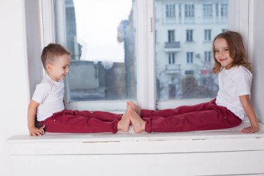 küçük erkek ve kız pencereden dışarı bakarak pencere oturmak