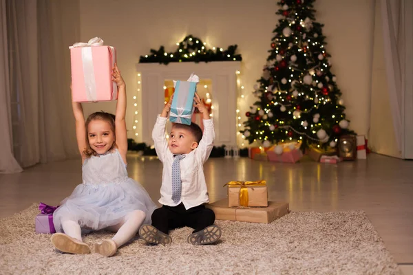 小男孩和女孩打开圣诞礼物新年冬天圣诞树 — 图库照片