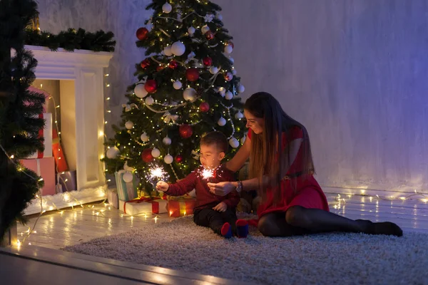 Mãe e filho novo sparklers presentes árvore de Natal ano novo — Fotografia de Stock