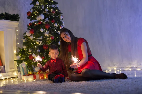 Мать и маленький сын сверкающие подарки новогодняя елка — стоковое фото