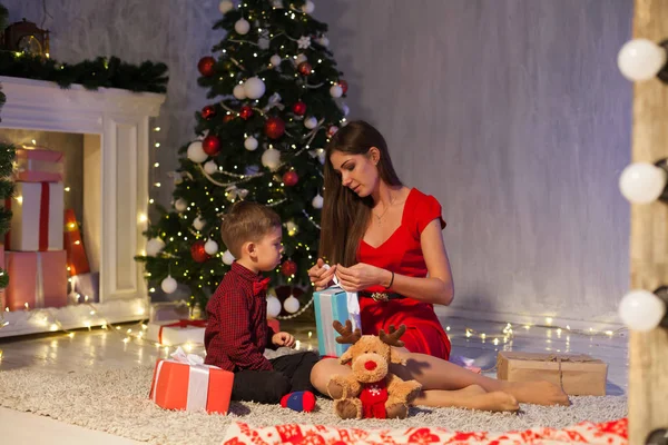 Мать и маленький мальчик открывают подарки Рождественская елка Новый год — стоковое фото
