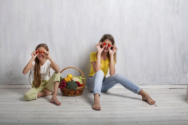 Bella ragazza con un cesto di verdure fresche, ravanelli, broccoli, pomodoro pepe — Foto Stock