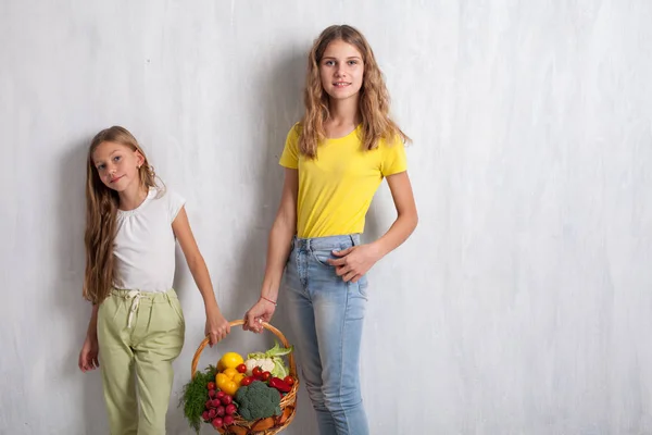 Bella ragazza con un cesto di verdure fresche, ravanelli, broccoli, pomodoro pepe — Foto Stock