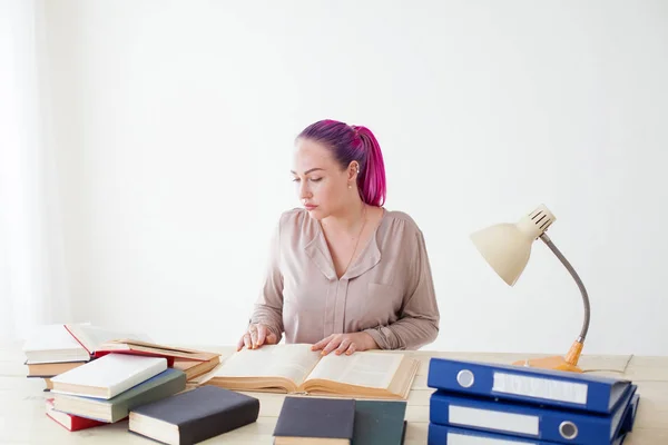 Hermosa mujer de negocios que trabaja en una oficina detrás de una mesa con libros — Foto de Stock