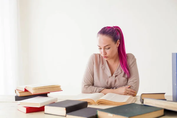 Hermosa mujer de negocios que trabaja en una oficina detrás de una mesa con libros — Foto de Stock