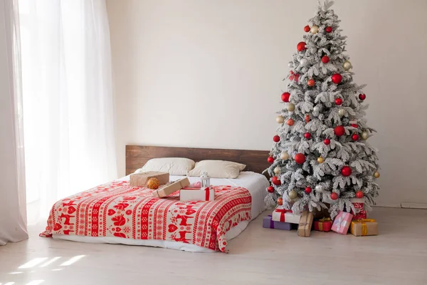 Weihnachtsbaum im Schlafzimmer mit Bett Lichter Neujahr Feiertagsgeschenke Girlande weiß Wohnkultur — Stockfoto