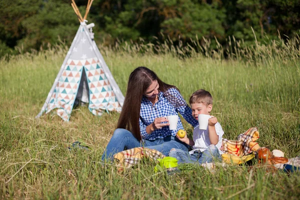 Matka i syn jedzenie na piknik na zewnątrz namiot — Zdjęcie stockowe