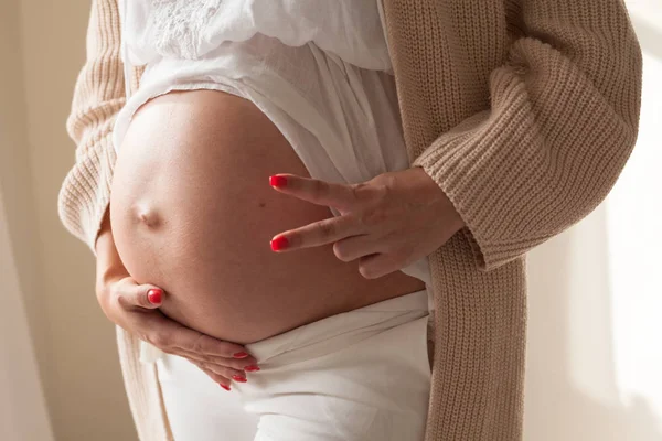 Schwangere zeigt zwei Finger bei der Geburt — Stockfoto