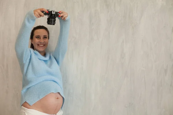 Vacker gravid kvinna med en kamera gör fotografier — Stockfoto