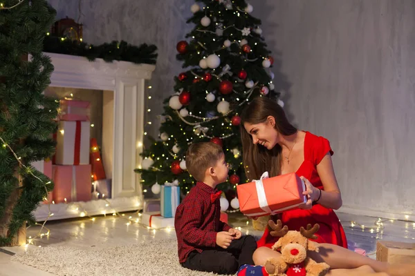 Madre e hijo abren regalos Navidad Año Nuevo vacaciones Guirnalda luces — Foto de Stock