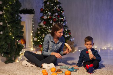 Anne ve oğlu hediye ışıklar Garland ile bir Noel ağacı, yılbaşı kutlamak