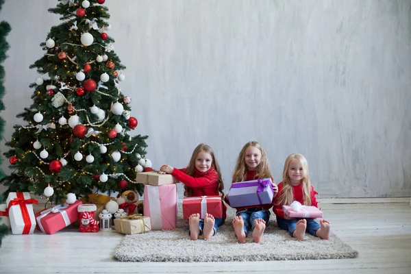 Три девушки открывают рождественские подарки новогодняя елка Гарланд — стоковое фото