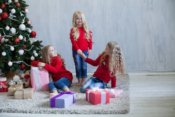 Três meninas abre presentes de Natal ano novo árvore de Natal Garland — Fotografia de Stock