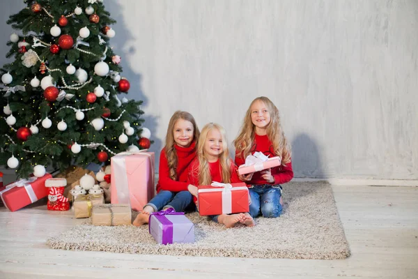 three girls opens Christmas presents new year Christmas tree Garland