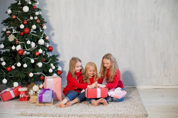 Três meninas abre presentes de Natal ano novo árvore de Natal Garland — Fotografia de Stock