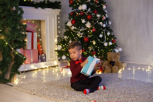 Kleiner Junge öffnet Weihnachtsgeschenke Neujahr Weihnachtsbaumgirlanden — Stockfoto