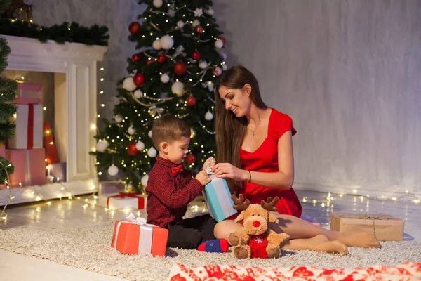 Mamá con hijo decorar árbol de Navidad regalos de año nuevo luces de guirnalda — Foto de Stock