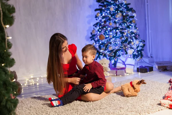 Maman avec fils décorer arbre de Noël nouveaux cadeaux de l'année Guirlande lumières — Photo