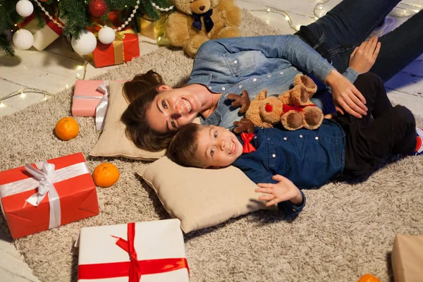 Мать и сын открывают подарки Рождественские огни Новый год — стоковое фото