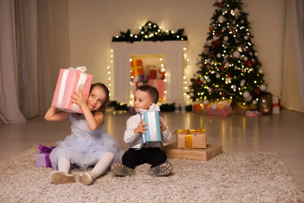Un ragazzo con una ragazza aperta Natale presenta Capodanno vacanza ghirlanda luci — Foto Stock